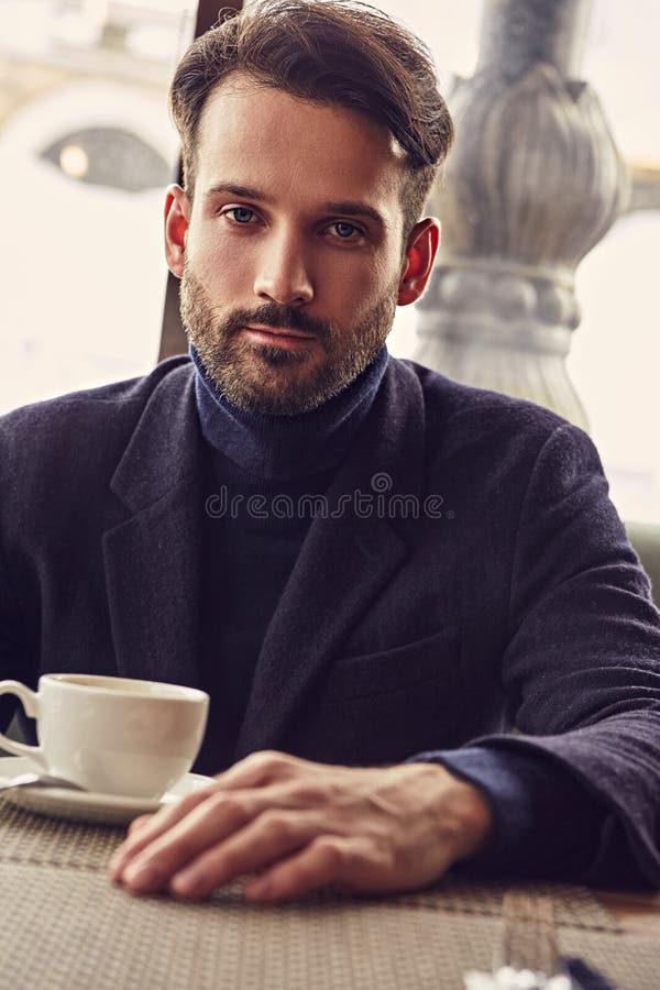 Thinking Handsome Man Sitting in Cafe and Drinking Cup of Coffee on the