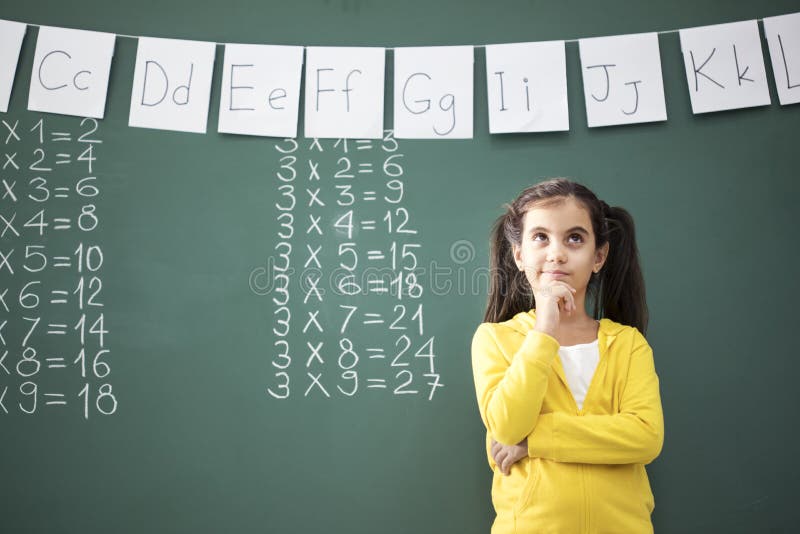 Thinking school child near blackboard stock photos Thinking school child near blackboard stock photos