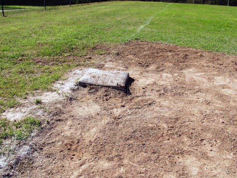 Third base bag in dirt and grass on a baseball field. Third base bag in dirt and grass on a baseball field.