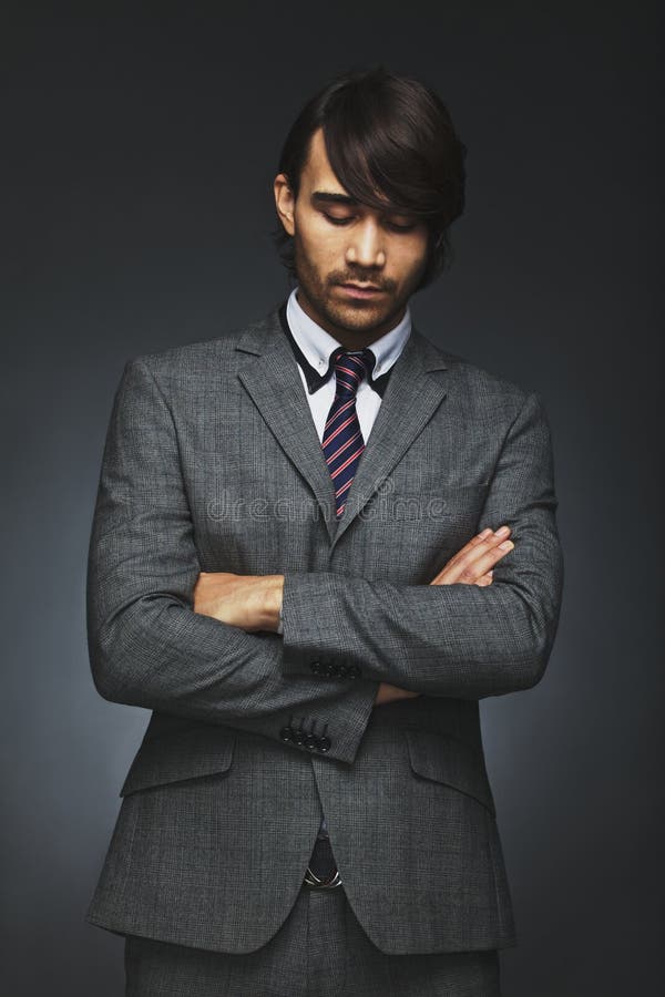 Thoughtful businessman in suit standing against black background royalty free stock image Thoughtful businessman in suit standing against black background royalty free stock image