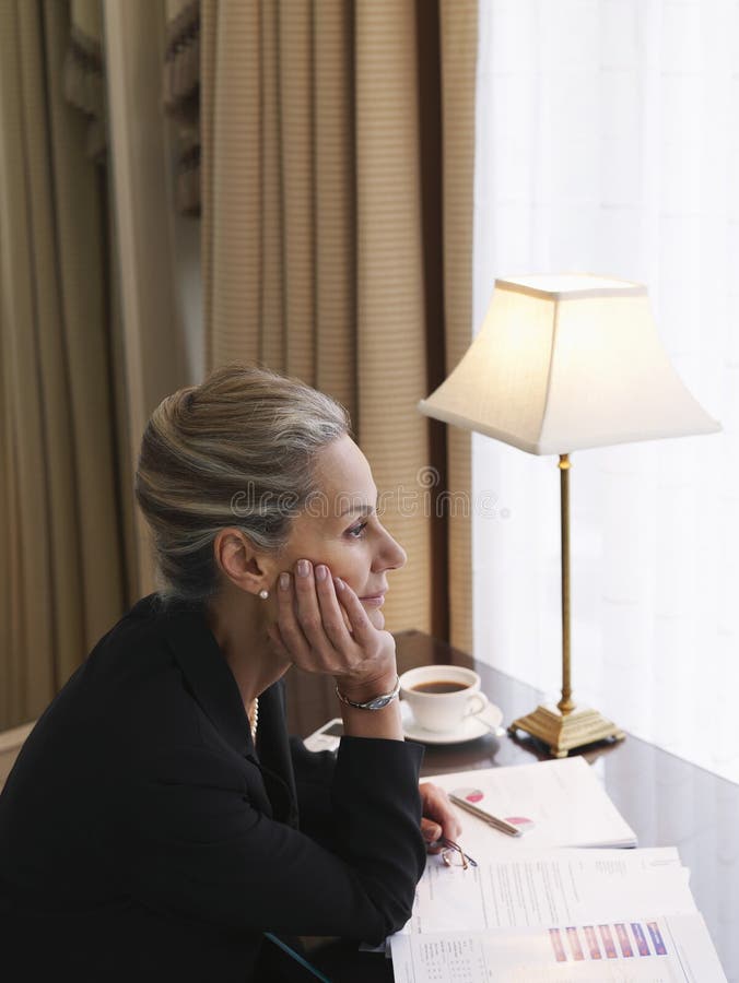 Thoughtful Businesswoman With Documents At Desk