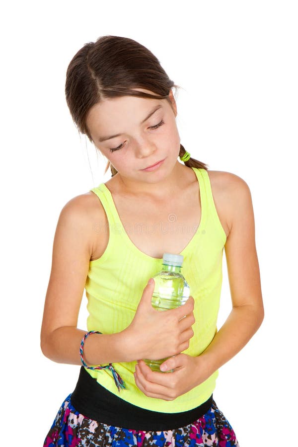 A thoughtful looking primary aged girl holding a full bottle of mineral water. A thoughtful looking primary aged girl holding a full bottle of mineral water.