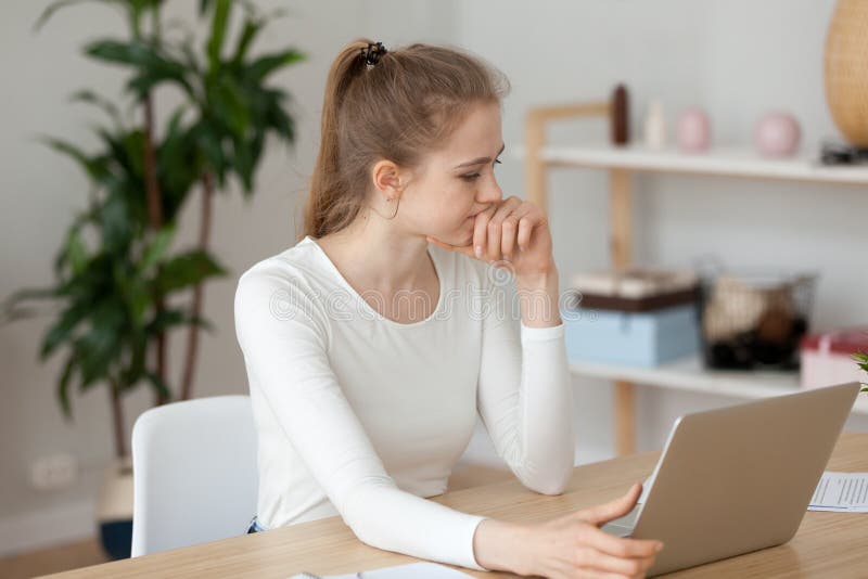 Thoughtful girl look at laptop screen having software problem stock photography