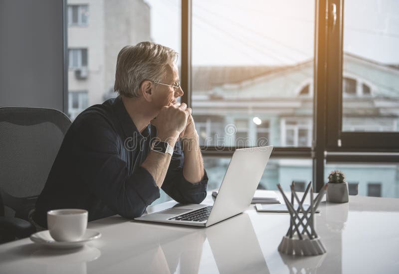 Thoughtful mature male worker watching at street stock photo Thoughtful mature male worker watching at street stock photo