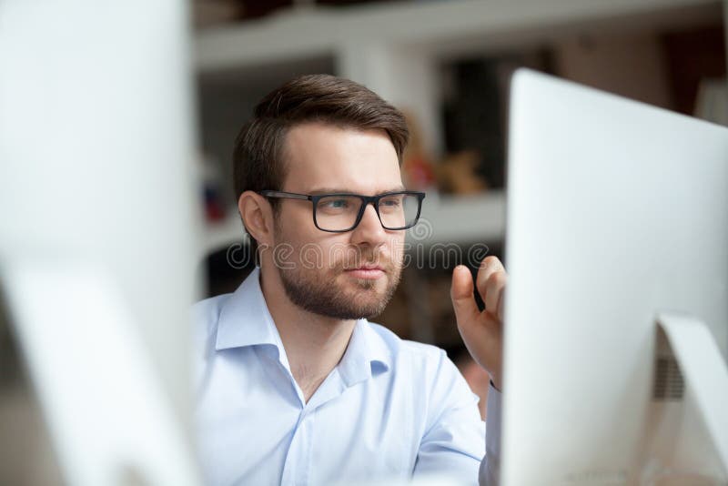 Thoughtful office worker thinking of problem solution looking at computer stock photography