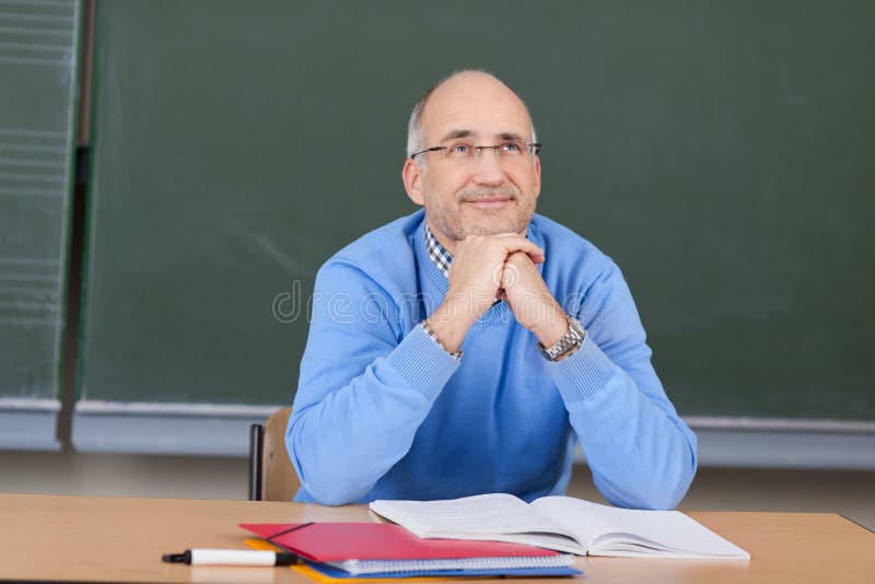 Thoughtful Professor With Hands On Chin Looking Up At Desk stock image