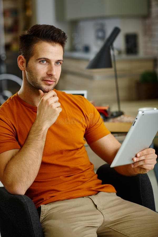 Thoughtful young man using tablet royalty free stock images