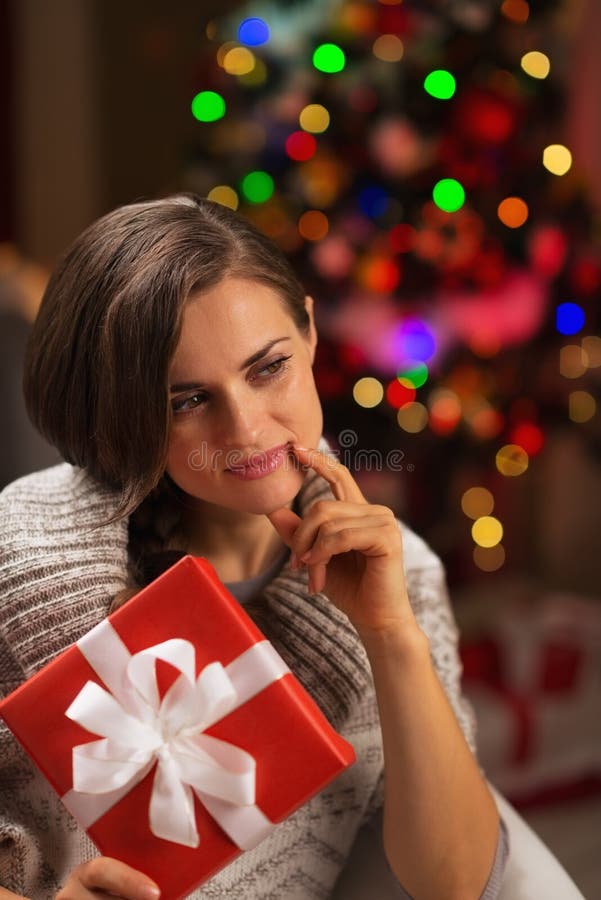 Thoughtful young woman with Christmas present box
