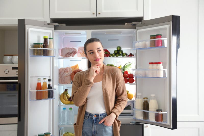 Thoughtful Woman Near Open Refrigerator in Kitchen Stock Photo - Image ...