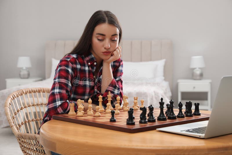 Premium Photo  Woman playing chess online uses laptop