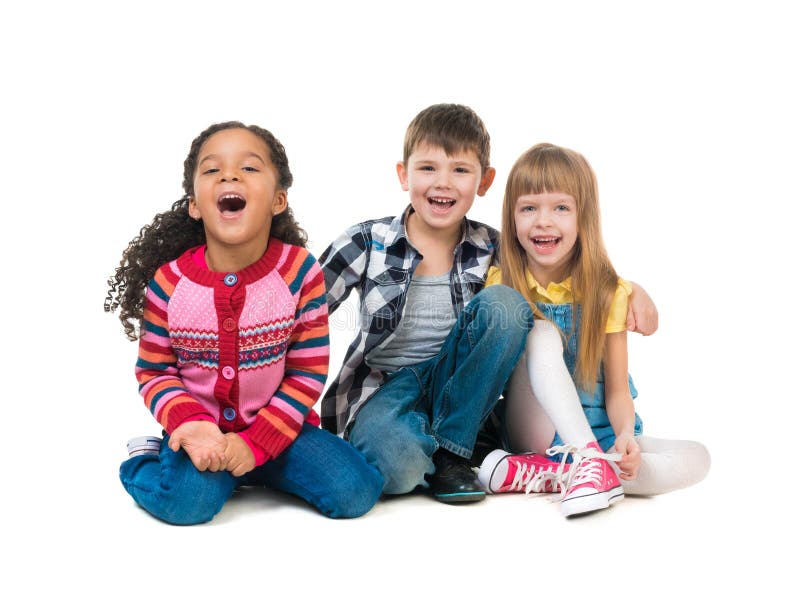 Thre cheerful kids sitting on the floor in a studio stock photo Thre cheerful kids sitting on the floor in a studio stock photo