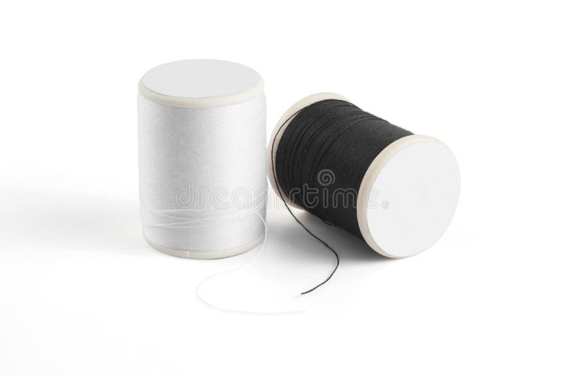 Thread spool on a white background. Basic color of thread: White, Black. A spools thread with shadow on a white background. Thread spool high angle view.