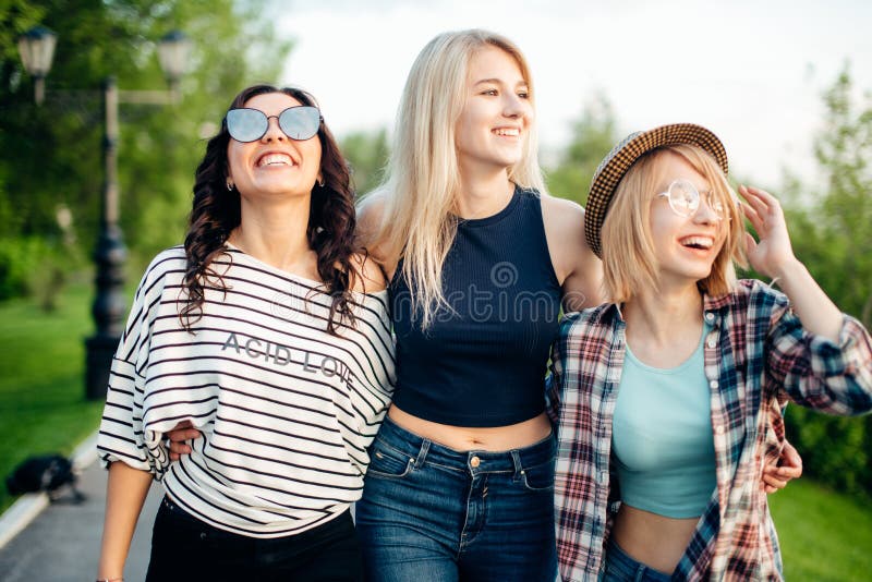 Three attractive young women talking a walking together stock photos Three attractive young women talking a walking together stock photos