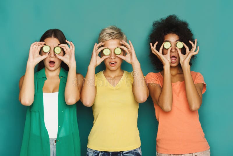 Three beautiful girls covering eyes with cucumber pieces royalty free stock photos Three beautiful girls covering eyes with cucumber pieces royalty free stock photos