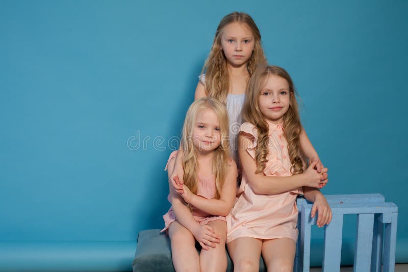 Three beautiful little girls dresses fashion portrait sisters