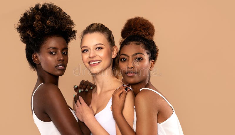 Three beautiful multi ethnic women posing together, looking at camera. Beauty portrait of two afro girl and one caucasian blonde. Skin care. Multiracial