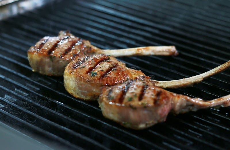 Three Beef Bone in Rib Eye Steak with Grill Marks on Grill Stock Image