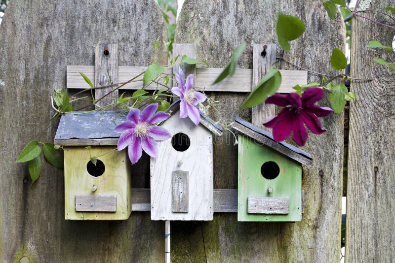 Three birdhouses on old wooden fence