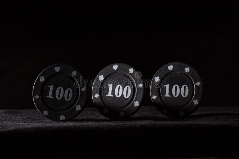 Three black poker chips on a dark background royalty free stock images Three black poker chips on a dark background royalty free stock images