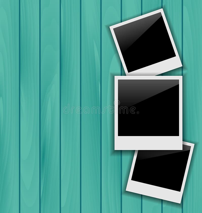 Three blank photo frames on wooden background