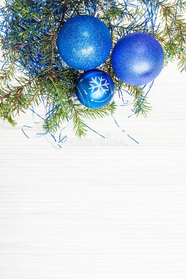 Three blue Xmas baubles and twig on blank paper. Christmas greeting card - border from three blue Xmas baubles and tree branch on blank paper background royalty free stock photography Three blue Xmas baubles and twig on blank paper. Christmas greeting card - border from three blue Xmas baubles and tree branch on blank paper background royalty free stock photography