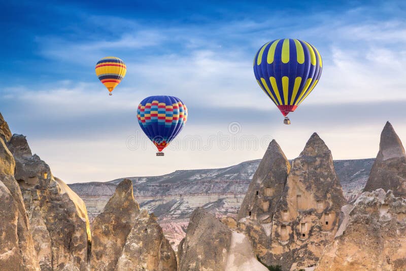 Three bright multi-colored hot air balloons flying in sky