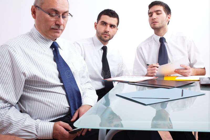 Three businessman sitting at table during meeting