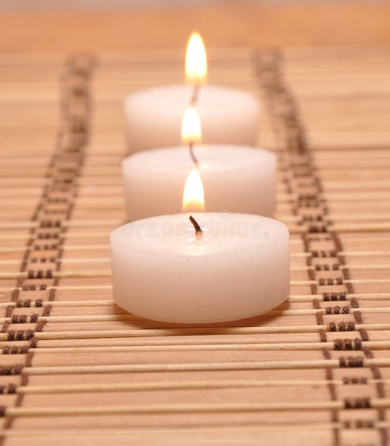 Three candles on a bamboo carpet