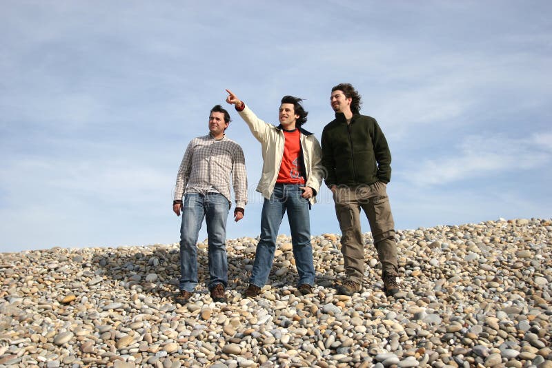 Three casual young men at the beach stock image