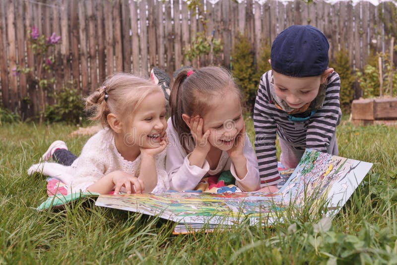 Three Children Play In The Garden On The Grass Stock Photo Image Of