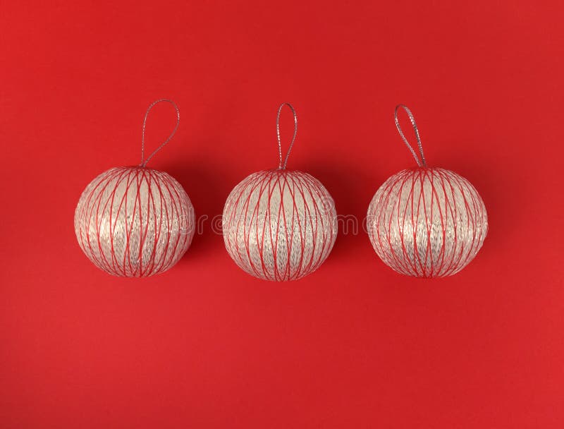 Three Christmas balls on a red background. Minimalistic holiday flat lay stock image