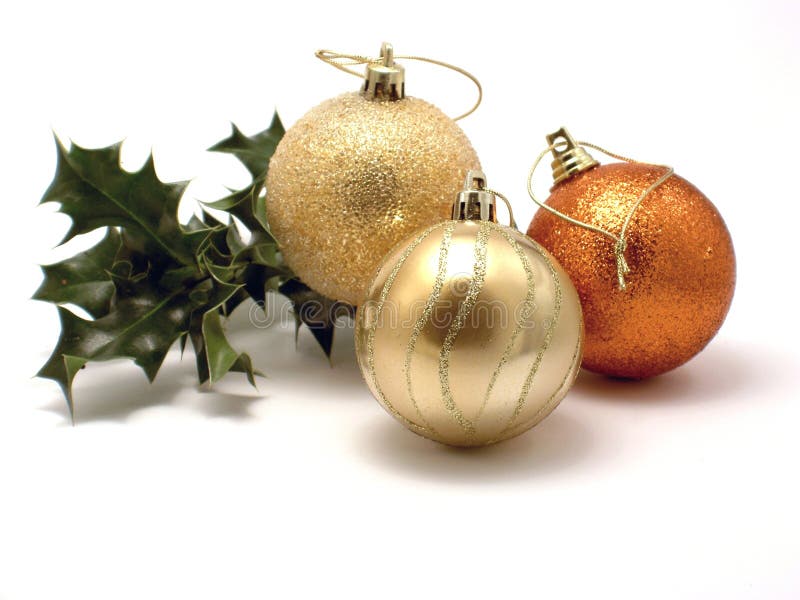 Three Christmas decorations and holly stock photos