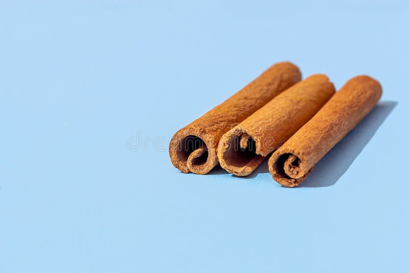 Three Cinnamon Sticks on a Blue Background Stock Photo - Image of isolated,  aromatic: 182604648