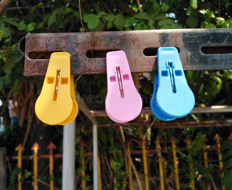 Three clothespin brihht colored plastic on steel with rust. Three clothespin brihht colored plastic on steel with rust in sunshine summer season royalty free stock images Three clothespin brihht colored plastic on steel with rust. Three clothespin brihht colored plastic on steel with rust in sunshine summer season royalty free stock images