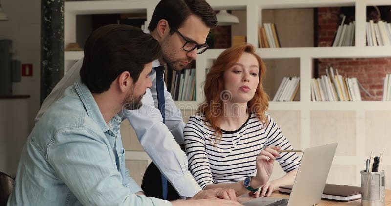 Three colleagues using laptop discussing online presentation stock video footage