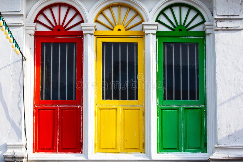 Three colored doors or windows outside on the facade of an ancient house