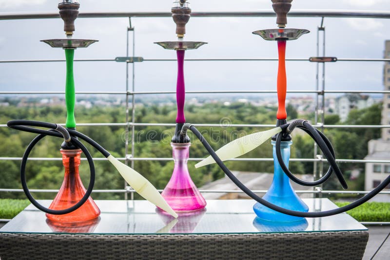 Three Colors Hookahs on Table in Hookah Lounge in a Day. Stock Photo
