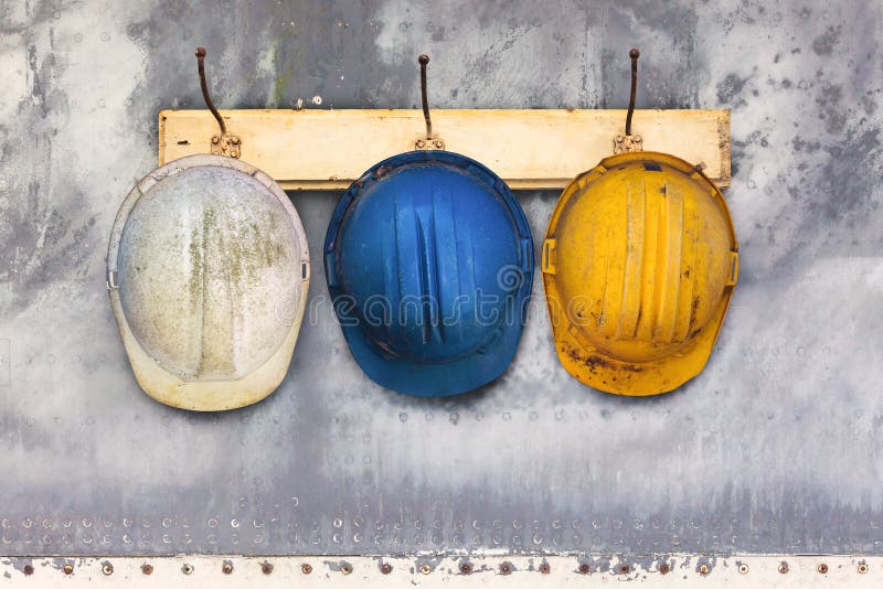 Construction Helmets Hanging On A Hat-rack Stock Image - Image of three