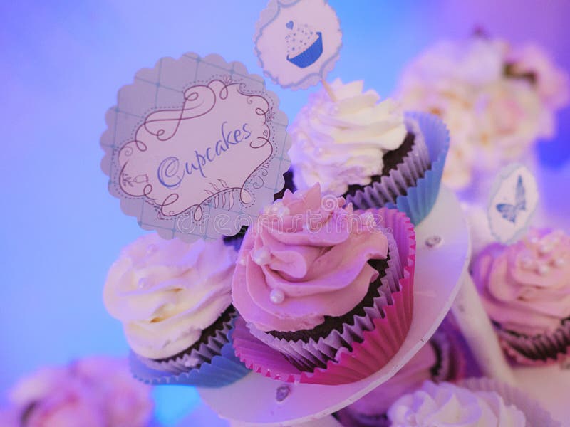 Special occasion trio of cupcakes on a tiered cake display with pink and white frosted cream royalty free stock images Special occasion trio of cupcakes on a tiered cake display with pink and white frosted cream royalty free stock images