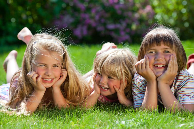 Three Cute Girls Outdoor in the Grass Smiling Stock Image - Image of ...