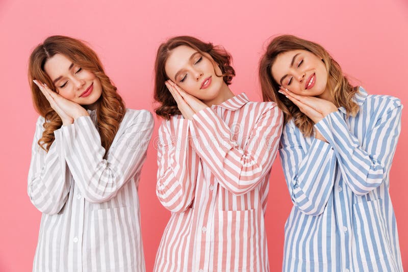 Three cute women 20s wearing colorful striped pajamas sleeping o