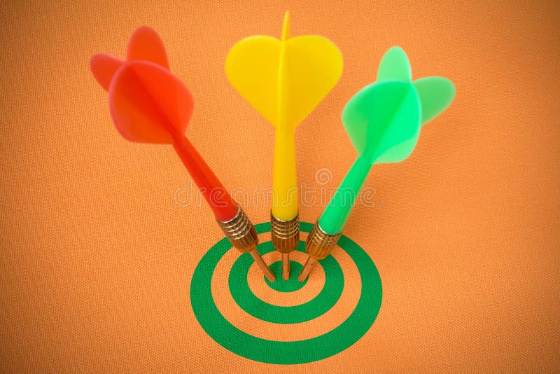 Three darts hitting green target stock images