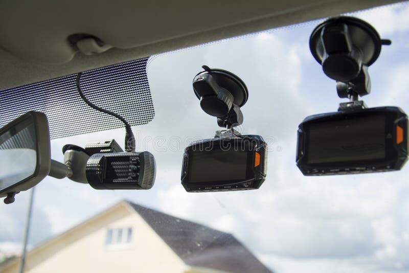 Three Dashboard Camera Mounted on the Dirty Front Windshield, Recording the Traffic Ahead in