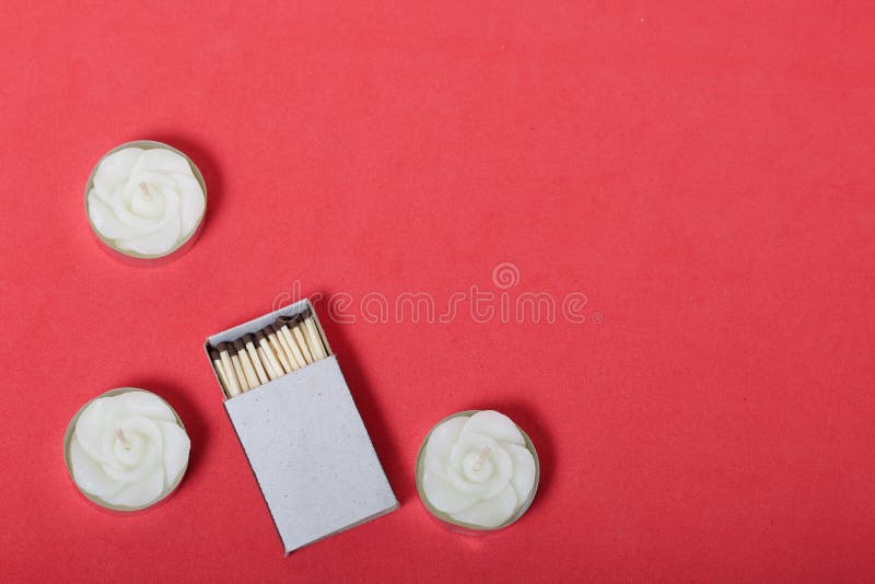 Decorative Candles, Matchboxes and Matches are Arranged in a Row. on a