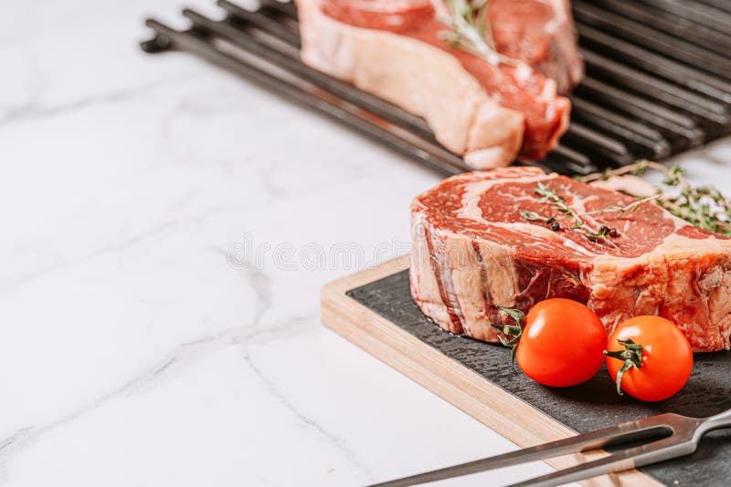 Three Delicious Steaks Ready To Grill on a White Marble Surface Stock