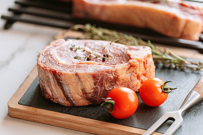 Three Delicious Steaks Ready To Grill on a White Marble Surface Stock