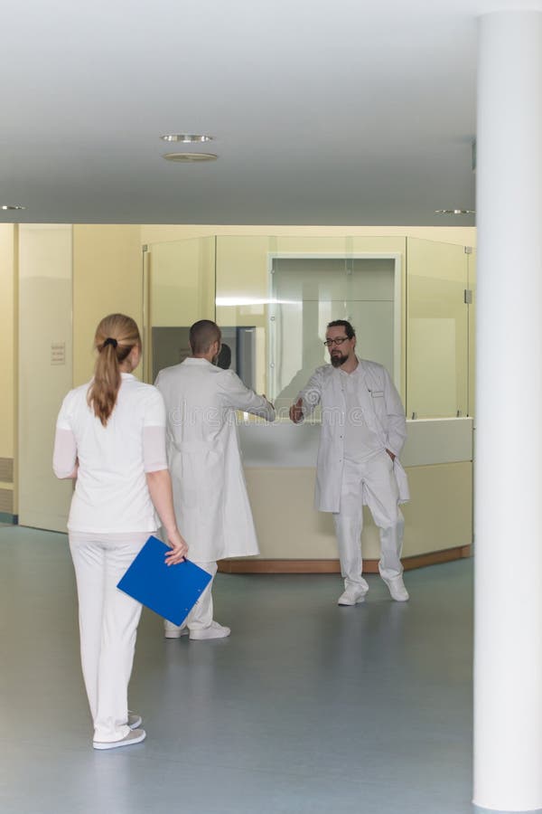 Three doctors in a hospital corridor royalty free stock image