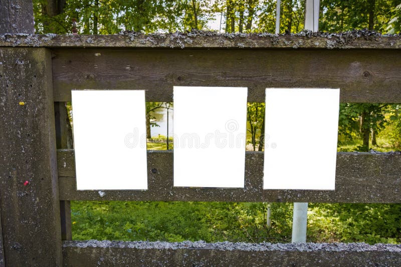 Three empty white notes on an old wooden fence stock photography