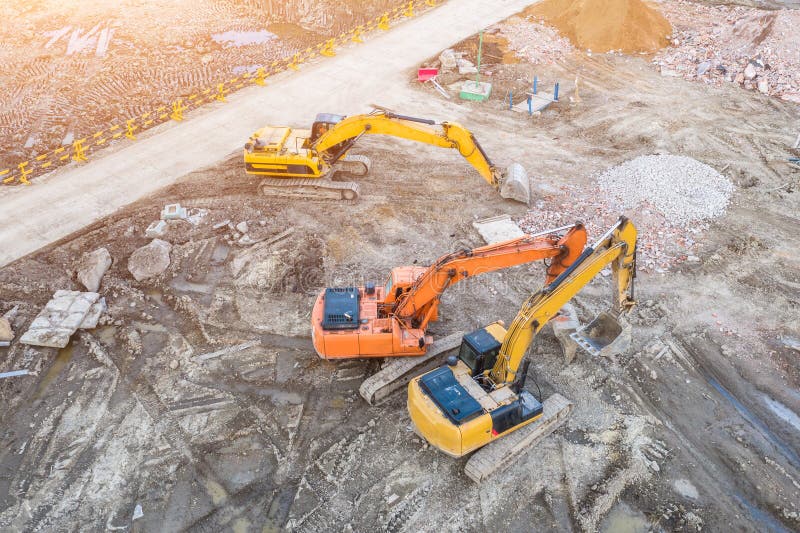 Three Excavators on Caterpillars in the Foundation Pit during the
