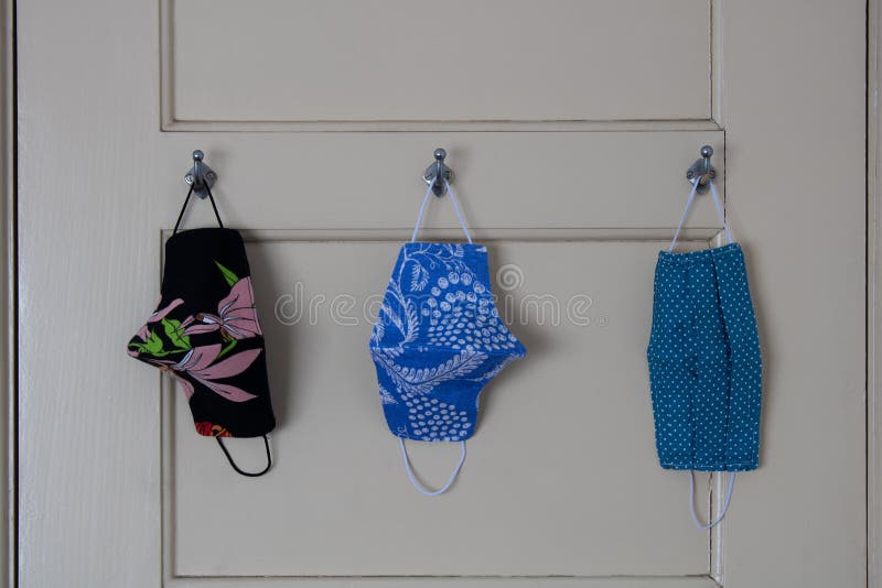 Three face masks hanging on door hooks